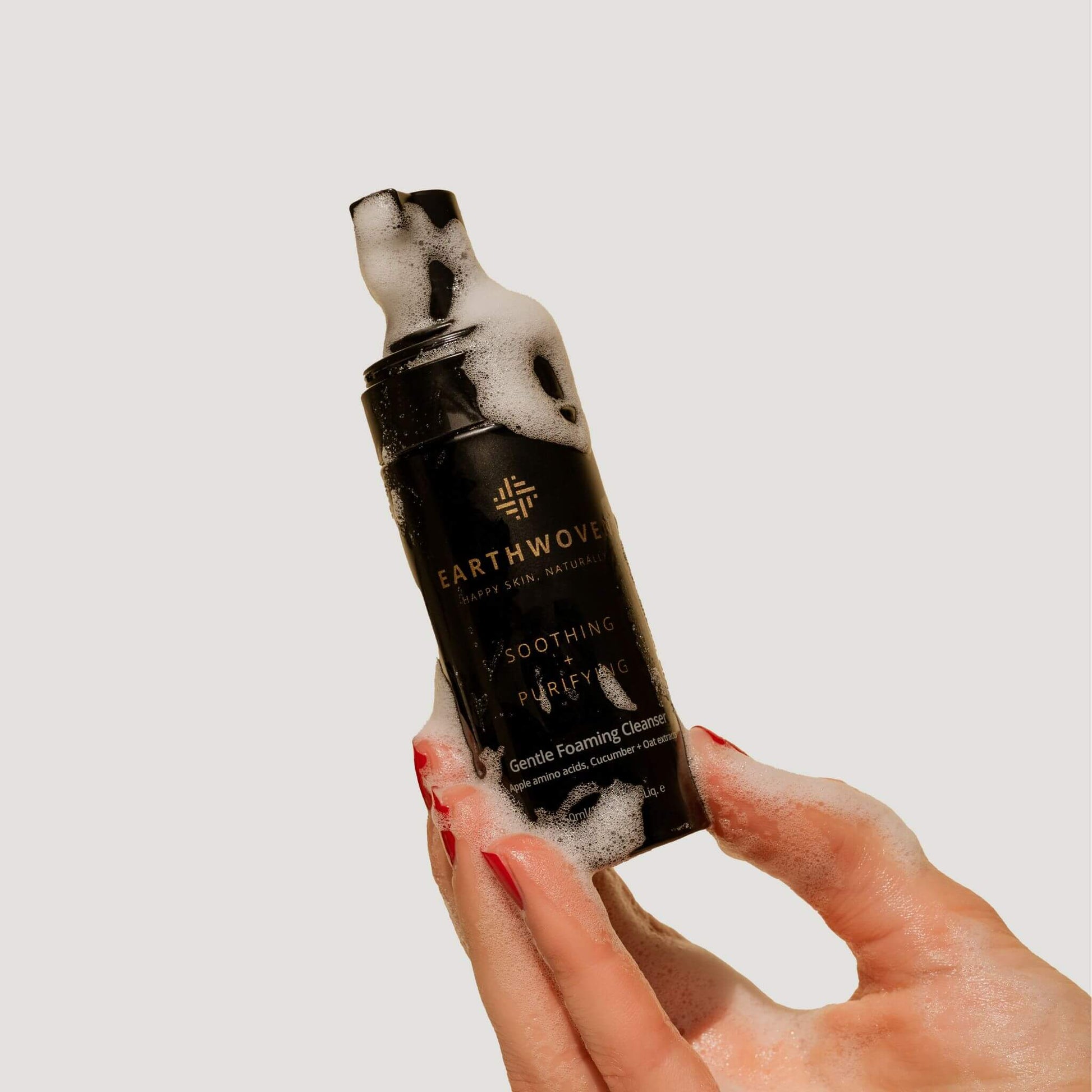 Earthwoven Gentle Foaming Cleanser lathered in hand, showcasing its soap-free formula for sensitive and acne-prone skin.